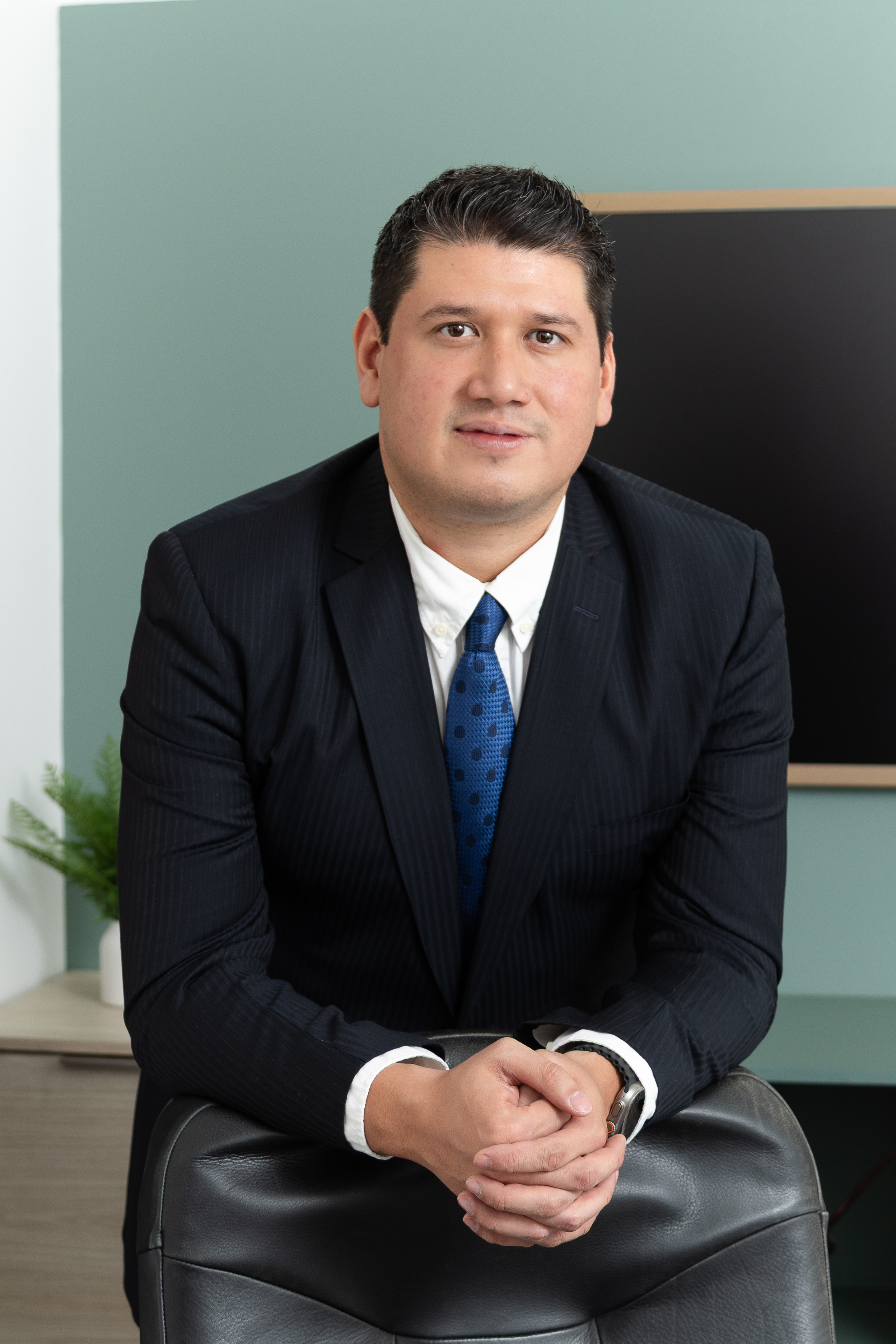 Doctor standing in front of his desk, looking at the camera.