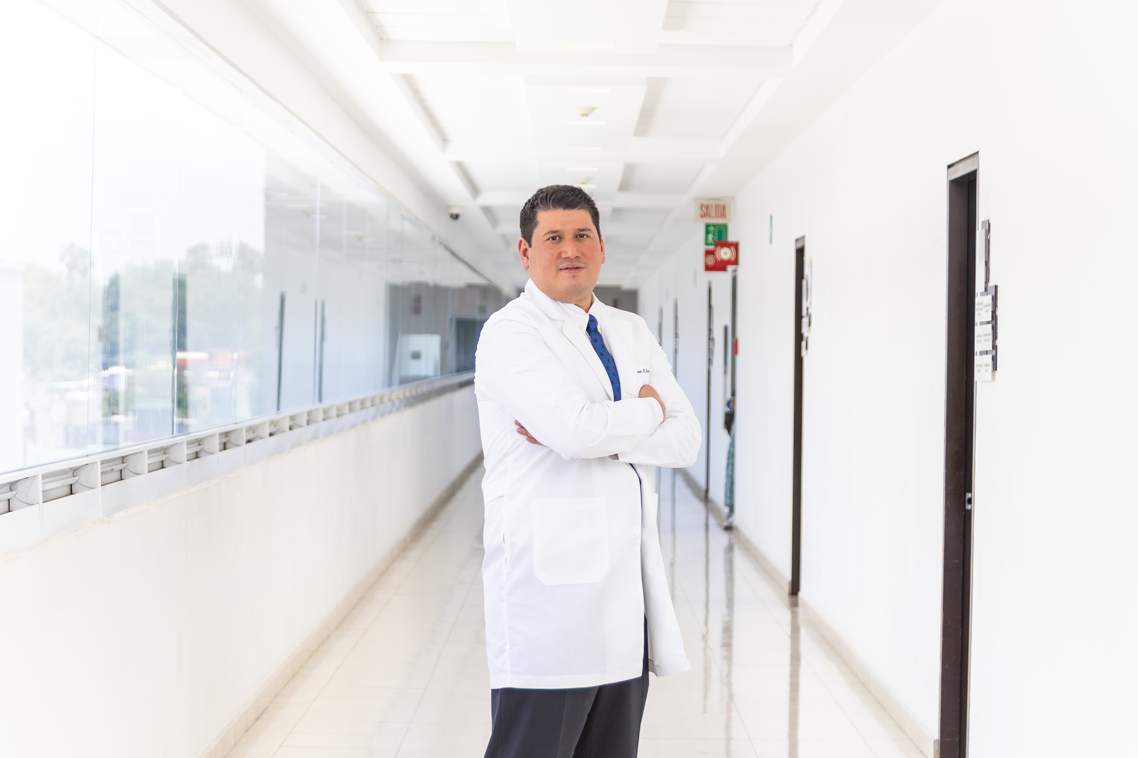 Doctor standing in foreground on a hall.
